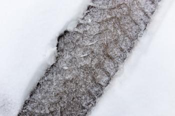 trace of the wheels on the snow as a background