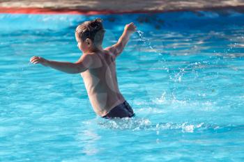 boy swims with a splash in the water park