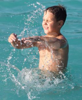 boy swims with a splash in the water park