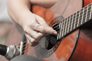 girl's hand playing guitar