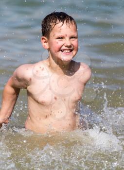 boy is bathed in the lake to the beach