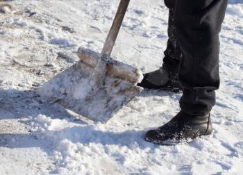 Worker cleans snow shovel