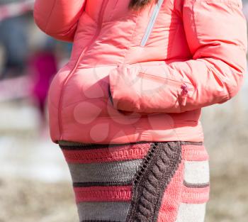 Pregnant girl in a pink jacket outdoor .