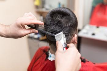Man's haircut trimmer in the beauty salon .