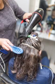 Styling female hair dryer in the beauty salon