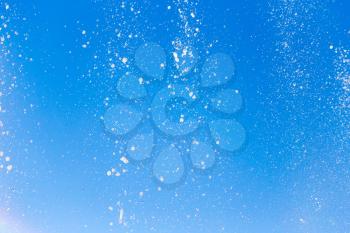 water splashing from the fountain in the background of blue sky .