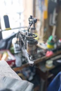 Sewing machine with a tailor's needle in the workshop