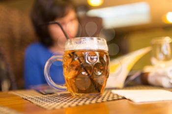 Girl with a mug of beer in a restaurant .