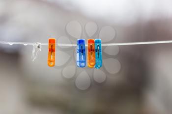 A Colorful clothespins on the clothesline outdoors .