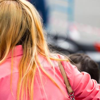 The strap from the bag hangs on the girl's shoulder .