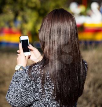 Girl with long hair with a cell phone .