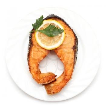 Salmon with lemon on a plate on a white background .