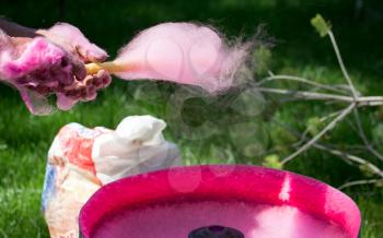 Making pink sweet cotton wool in the park .