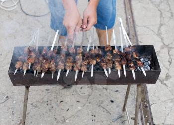 Cooking barbecue sticks on the grill in the open air