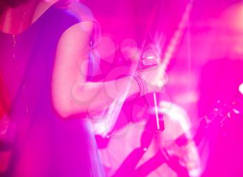 Microphone in the hands of the girl on stage .