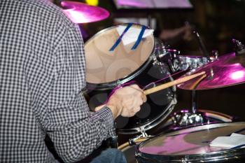 Musician plays drums in a rock band .