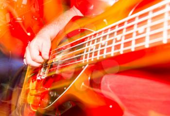 Musician playing guitar in a rock band .