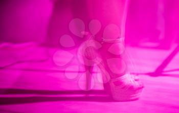 Feet of a girl on stilettos on stage .