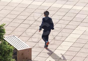 The boy runs quickly over the pavement