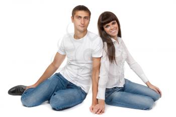 Attractive young loving couple sitting on floor, smiling happily