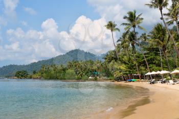 tropical beach with sun beds and umbrellas, palm trees, Thailand