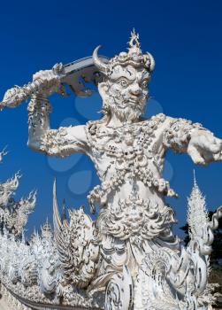 sculpture soldier guards the entrance to the White temple in Chiang Mai, Thailand
