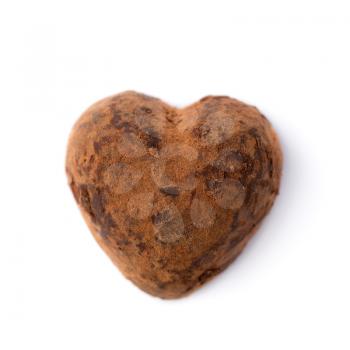 One truffle candy in a heart shape. Closeup isolate on white. Shallow depth of field. Valentine's Day.
