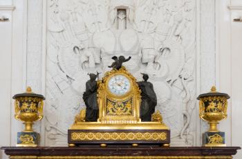 Antique clock in gold case in the interior Hermitage Museum, St. Petersburg.