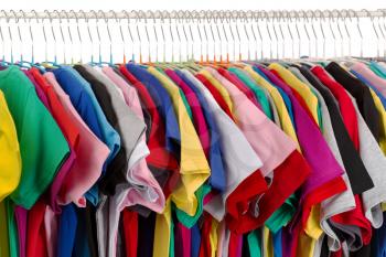 Rack of assorted colored T-shirts. Isolate on white.
