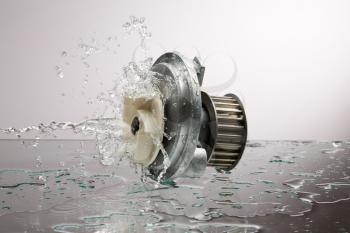 Auto parts, engine cooling pump in water splash on gray gradient background