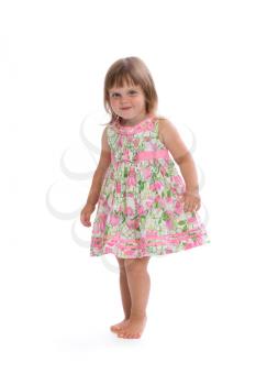 Charming little girl in a bright dress with a floral pattern. Isolate on white.