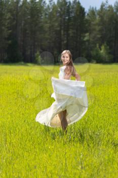 A girl in a white dress in a field.