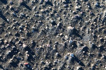 Background, black sand and pebbles.