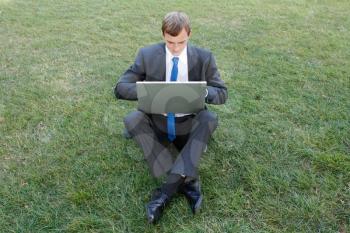 Royalty Free Photo of a Businessman Using a Laptop Outside