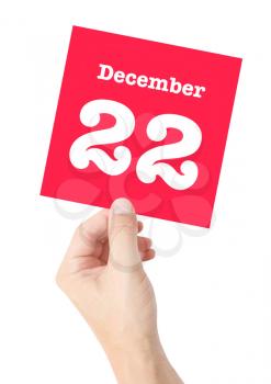 December 22 written on a card held by a hand