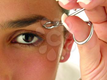 Royalty Free Photo of a Woman Plucking Her Eyebrows