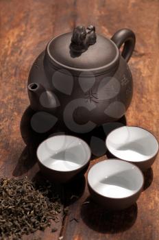 chinese green tea traditional  pot and cups over old wood board 