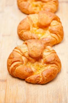 three fresh baked french croissant brioche on wood board