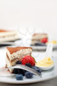 classic Italian tiramisu dessert with berries and custartd pastry cream on side 