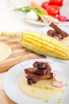 traditional Italian roasted pork ribbs served on polenta bed,corn cream