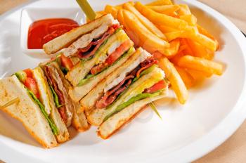 fresh triple decker club sandwich with french fries on side