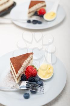 classic Italian tiramisu dessert with berries and custartd pastry cream on side 