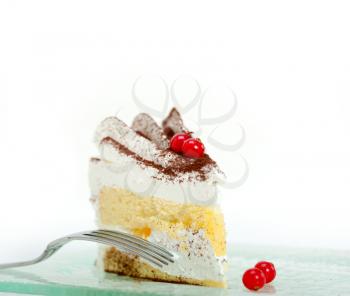 fresh ribes and whipped cream dessert cake slice with cocoa powder on top