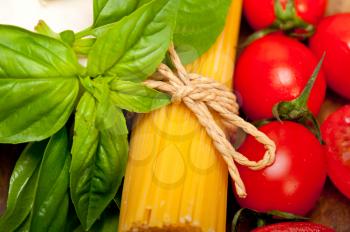  raw ingredients spaghetti pasta tomato and basil foundations of Italian cuisine