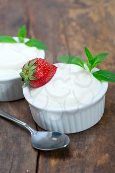 organic Greek yogurt and strawberry on a rustic wood table