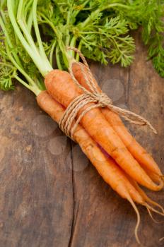 fresh baby carrots bunch tied with rope on a rustic table