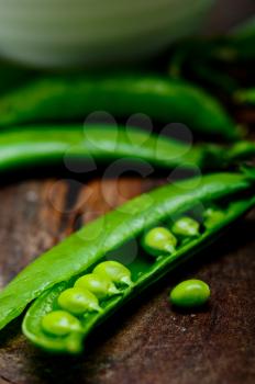 hearthy fresh green peas  over a rustic wood table