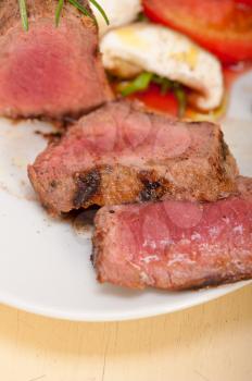 beef filet mignon grilled with fresh vegetables on side ,mushrooms tomato and arugula salad