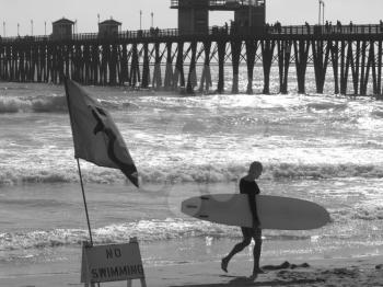 Royalty Free Photo of a Person Carrying a Surfboard