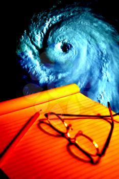 Royalty Free Photo of a Notebook and Map Tracking a Hurricane